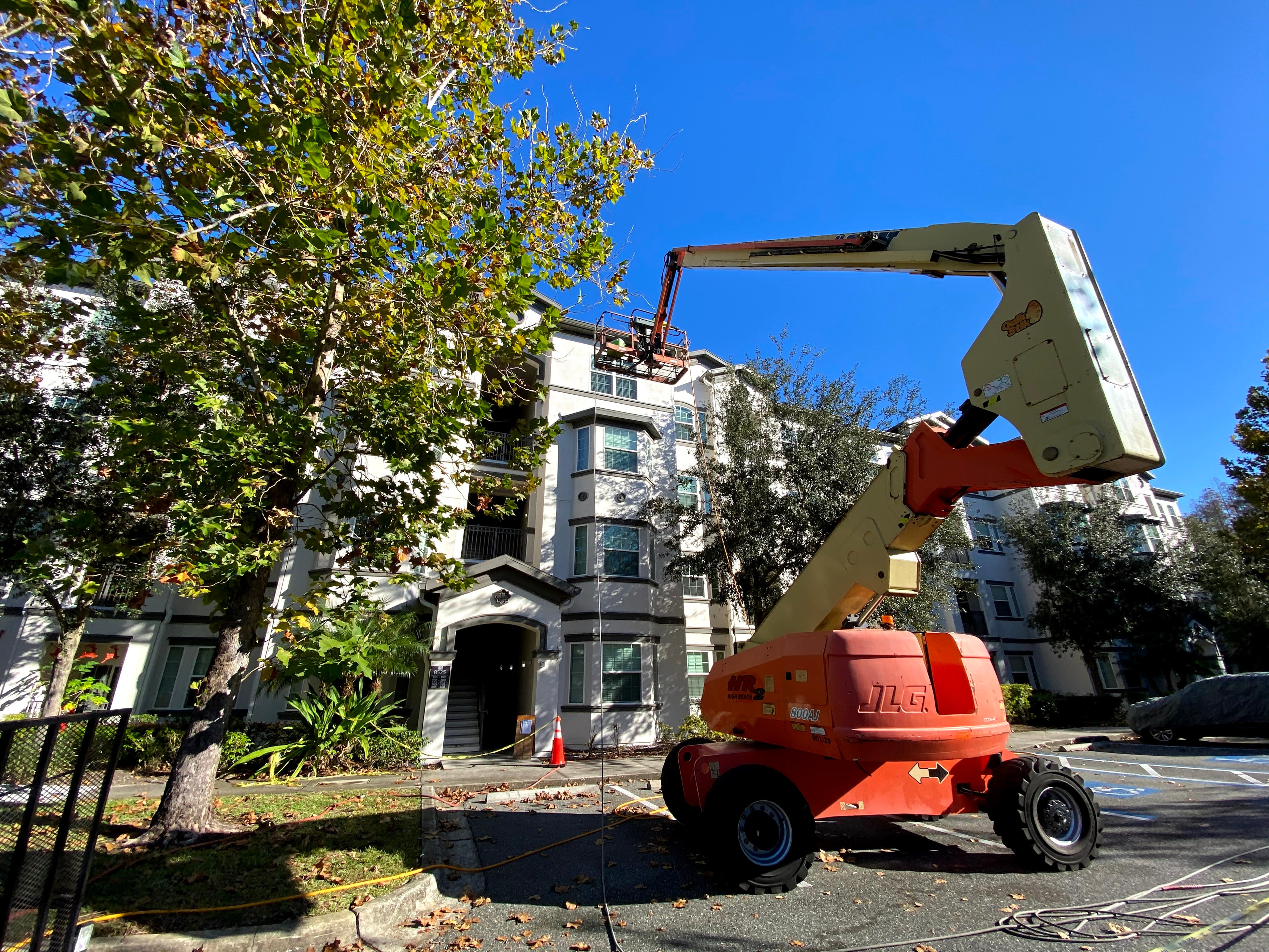 Window cleaning technician on cherry picker boom lift